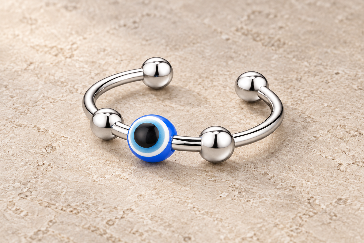The Evil Eye Ring with a blue eye bead and polished silver beads on an open band.