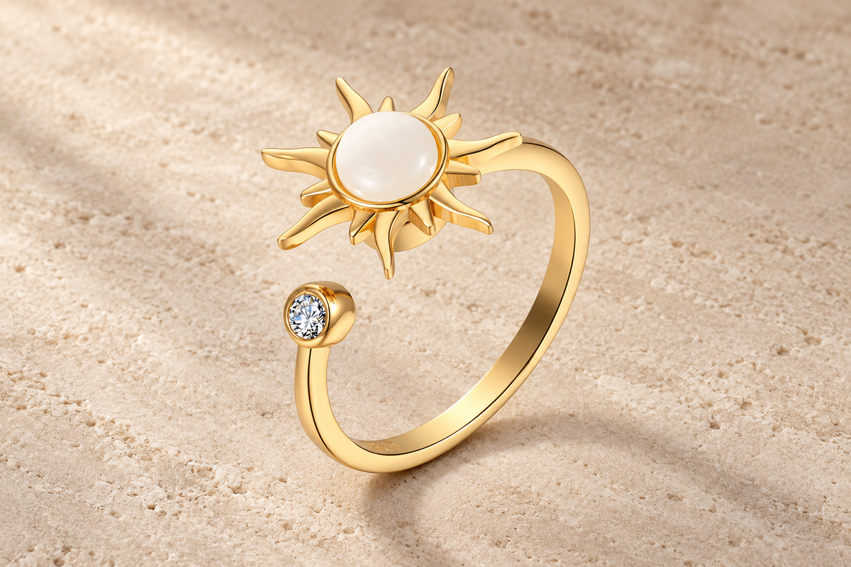 The Sunstone Ring with a pale pearly center, gold sun rays and an open band.