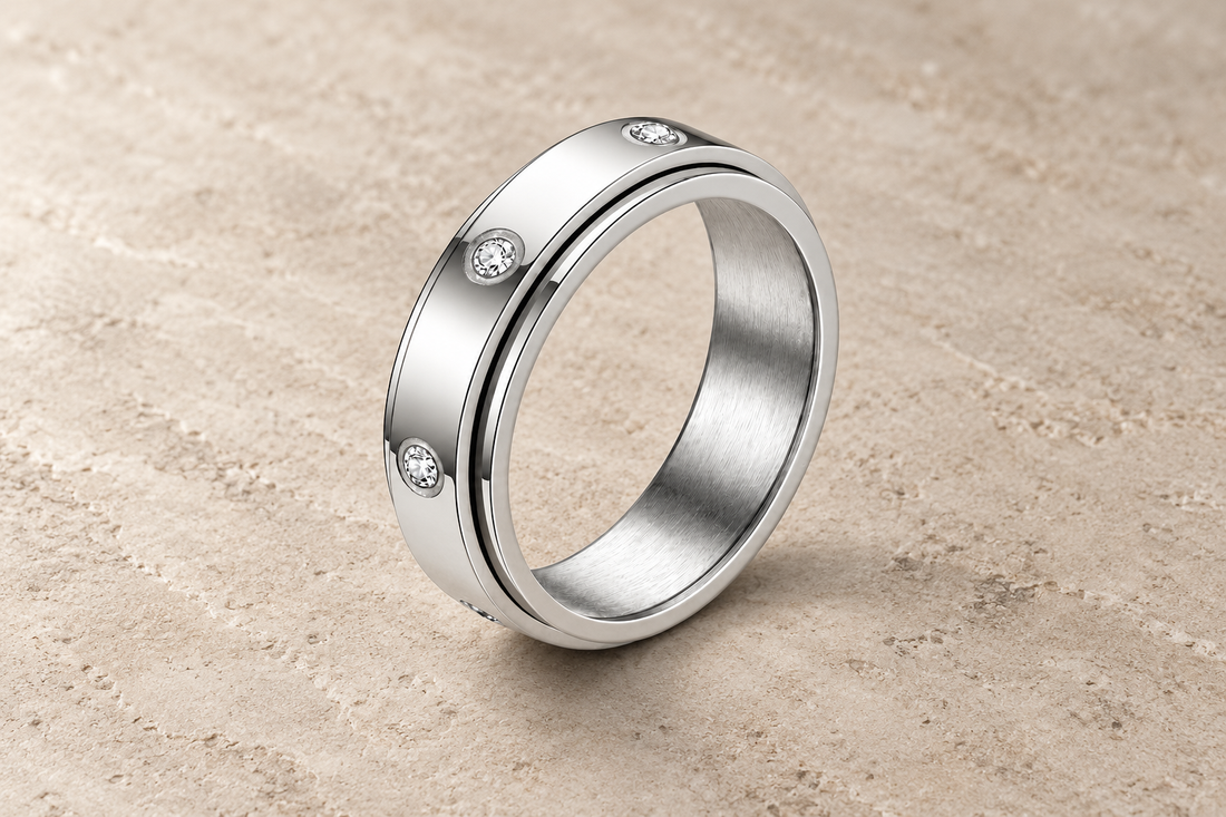 The Orbit Ring in silver with clear bezel-set crystals and a separate rotating outer band.