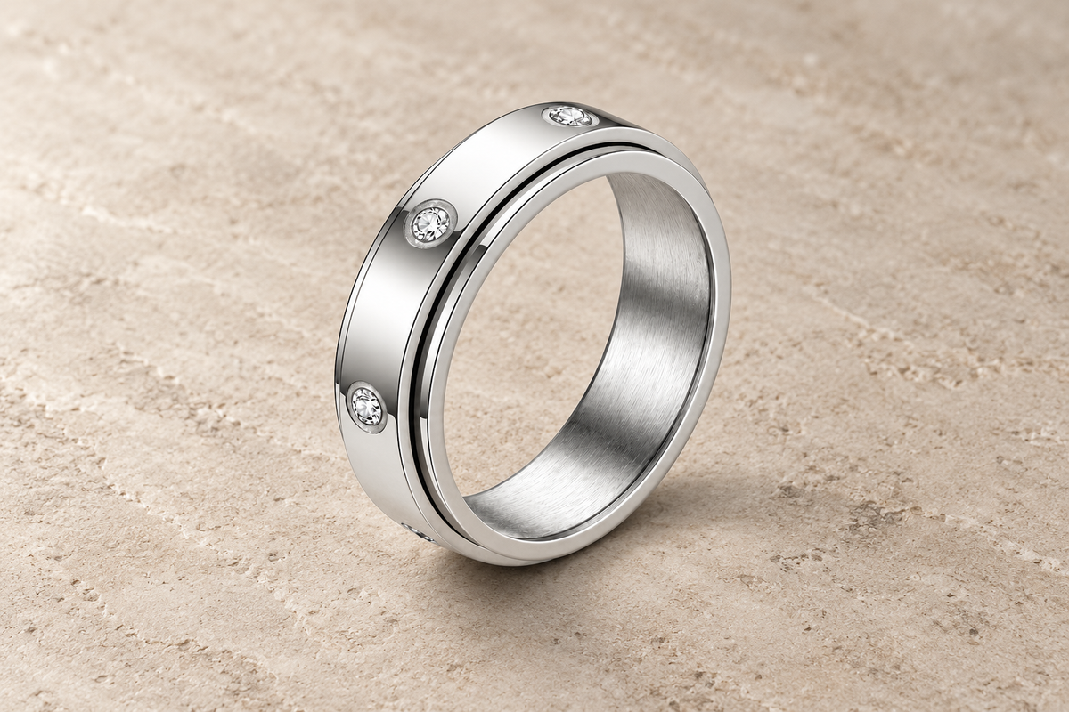 The Orbit Ring in silver with clear bezel-set crystals and a separate rotating outer band.